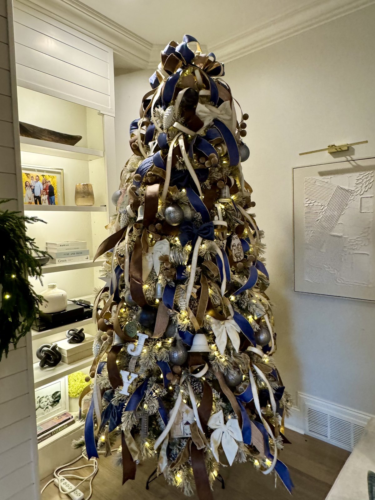 Navy, bronze and cream ribbon Christmas tree in a styled living room